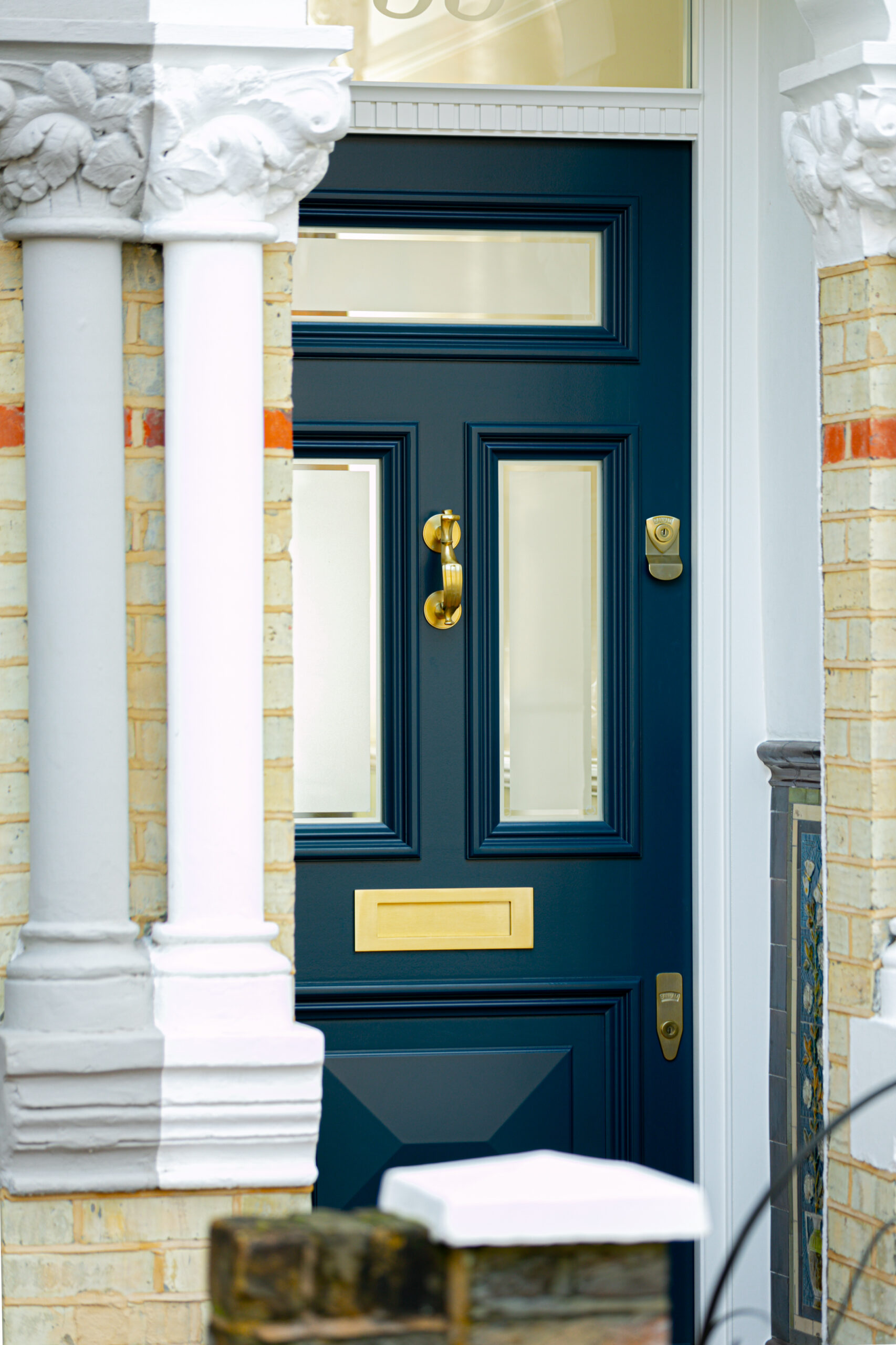 Deep blue front door with bronze detailing