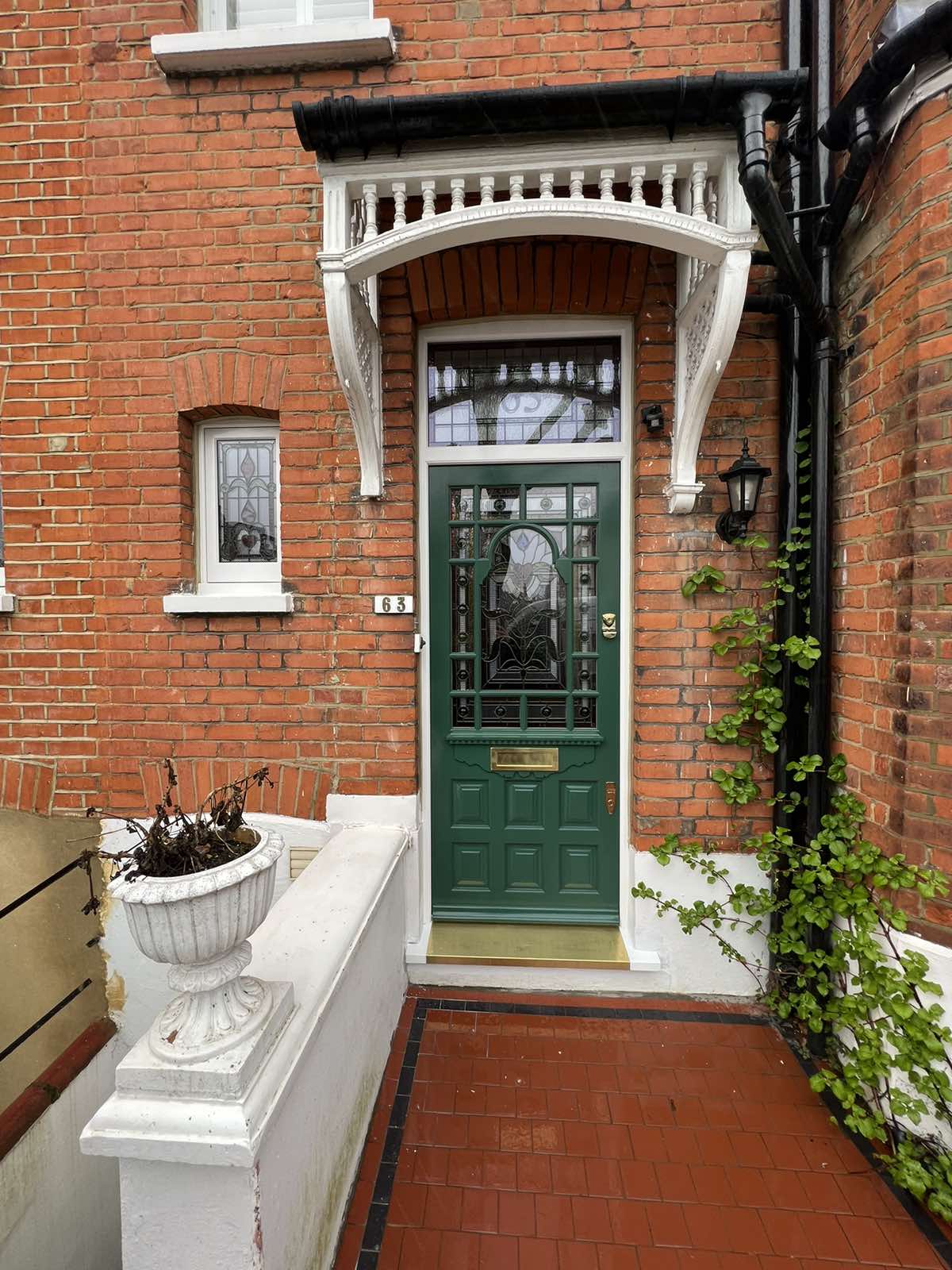 Detailed green front door entrance against red brick