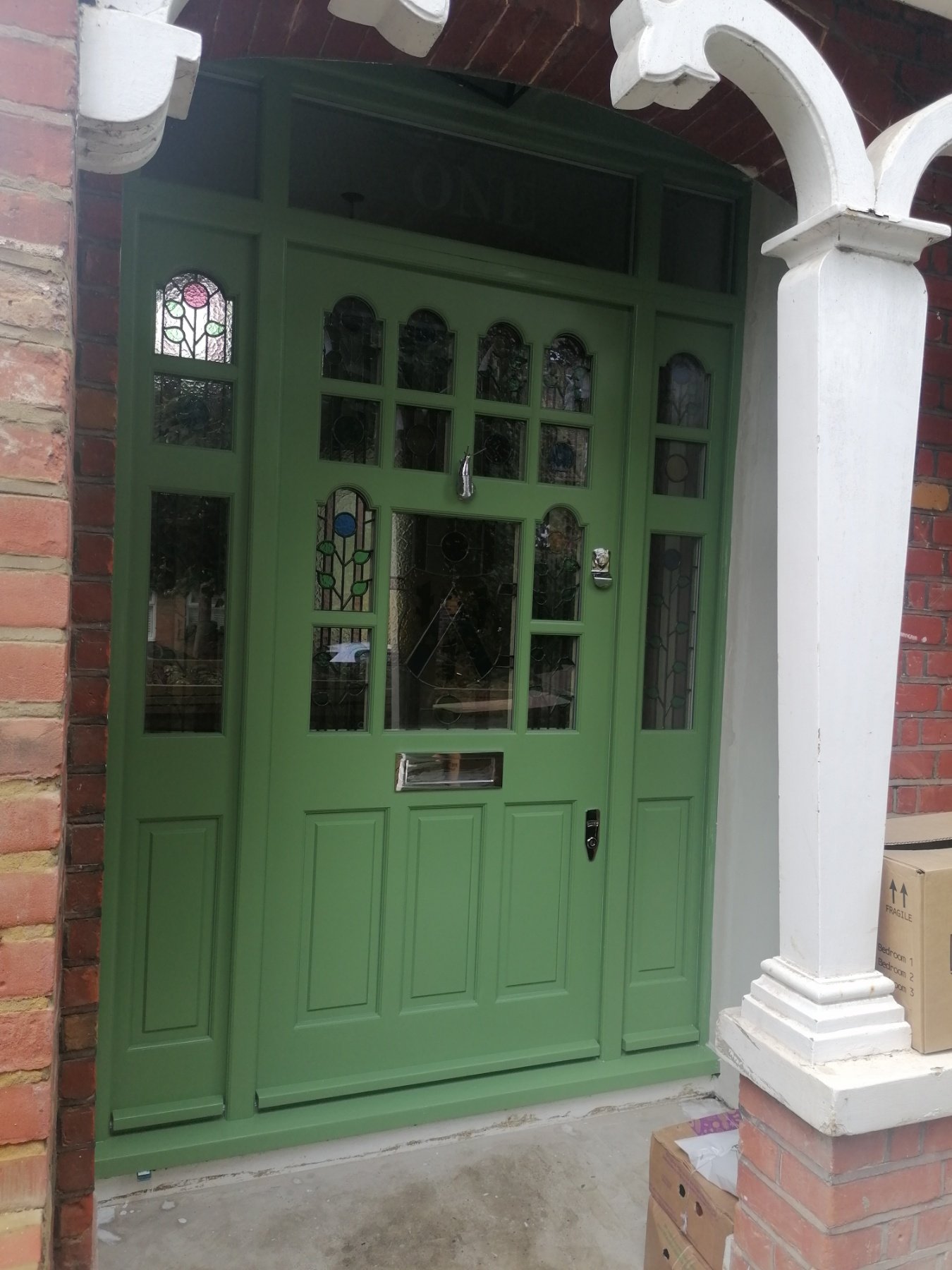 Garden green front door with sidelights and transom windows
