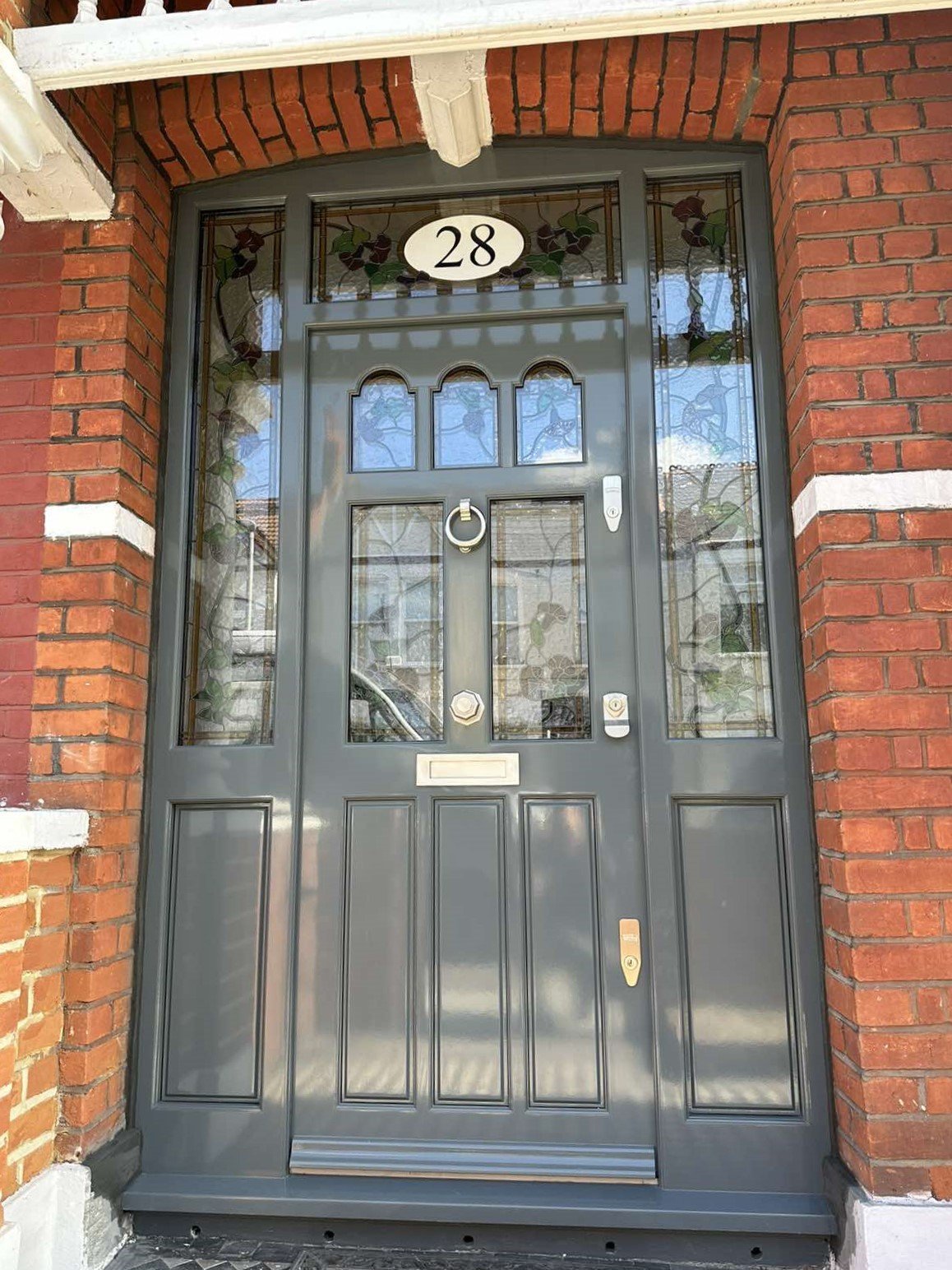 Grey front door with transsom windows and sidelights
