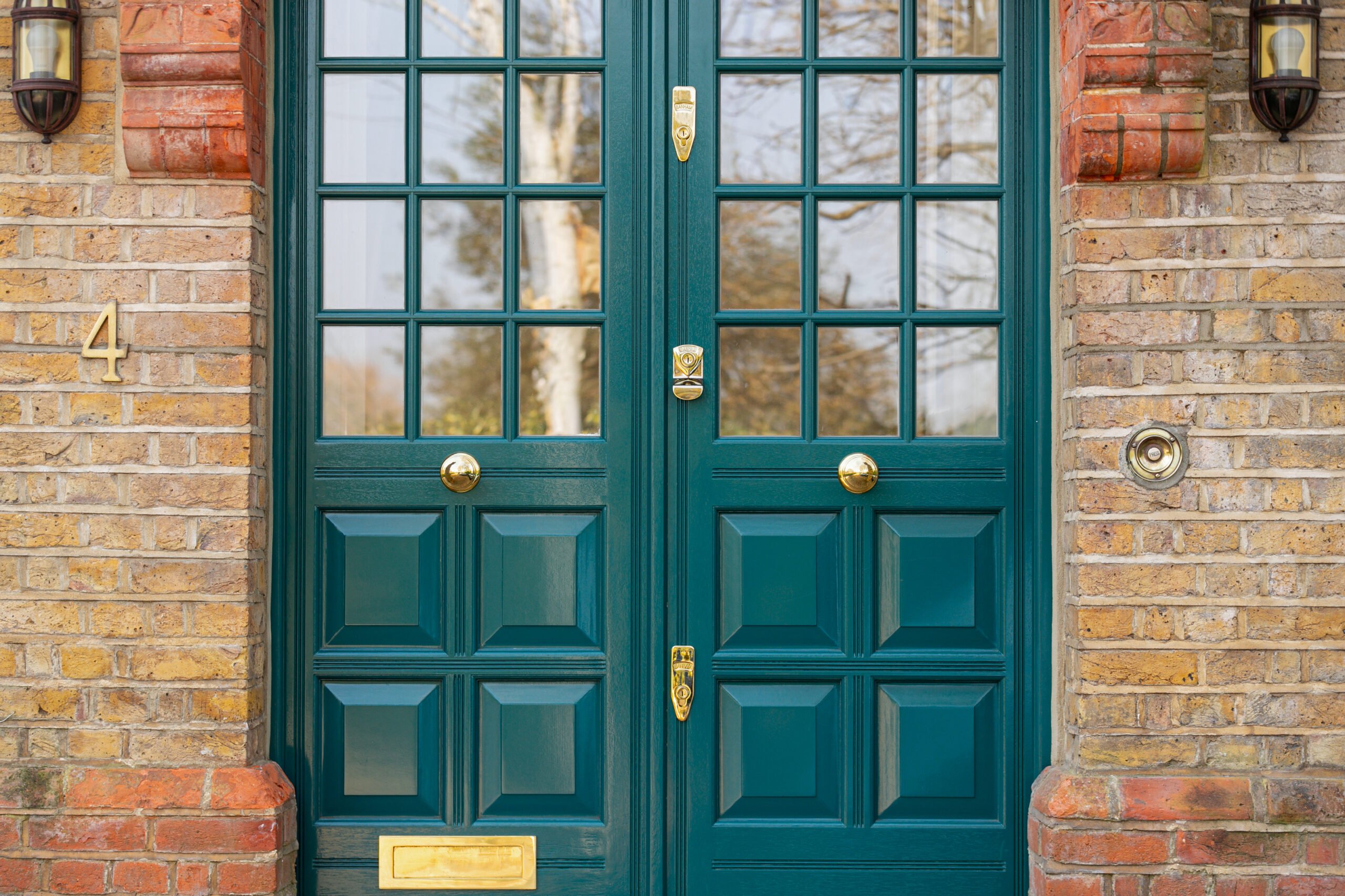 Obsidian green double front door against brick