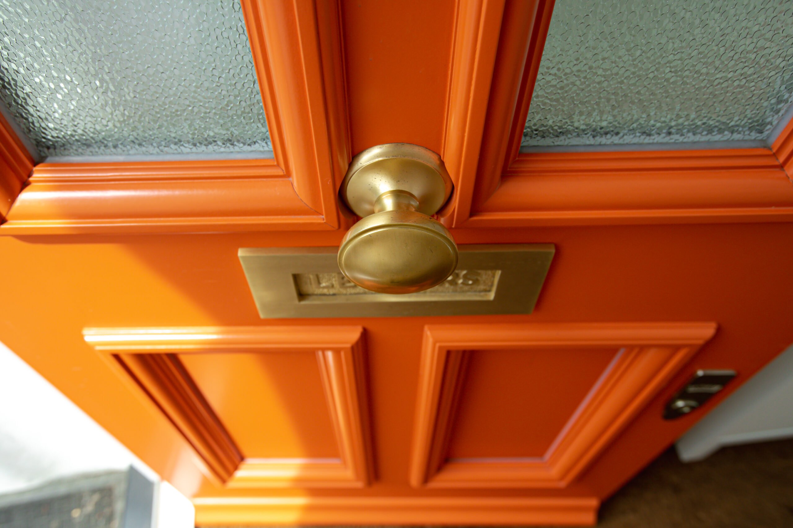 Orange front door with bronze