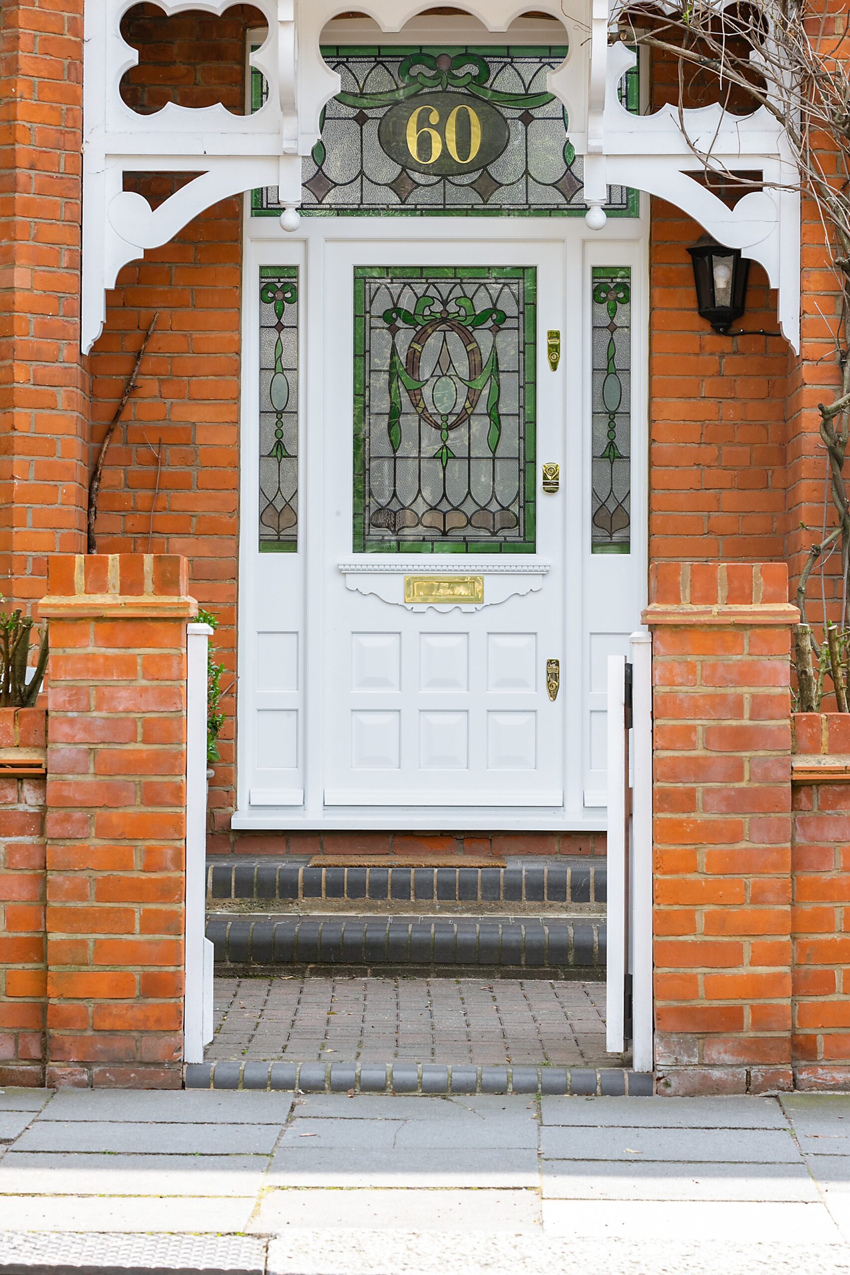 Ornate entrance with a white front door and red brick