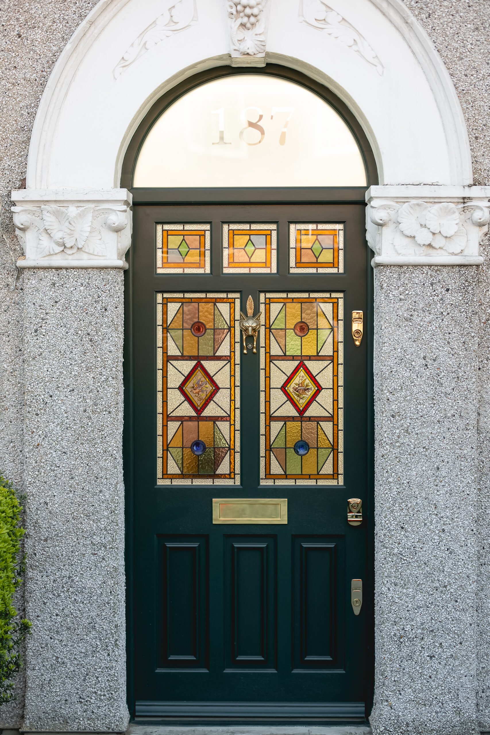 Ornate green front door with stained glass