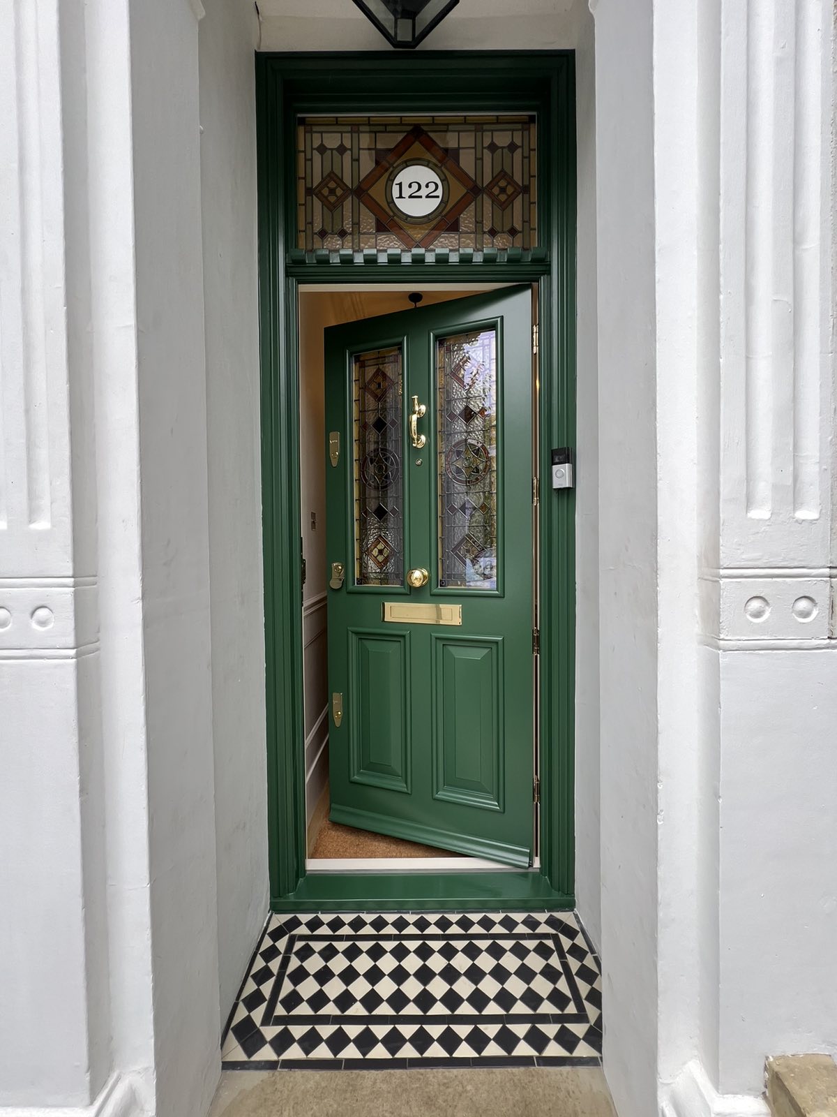 Ornate olive front door with stained glass transom windows