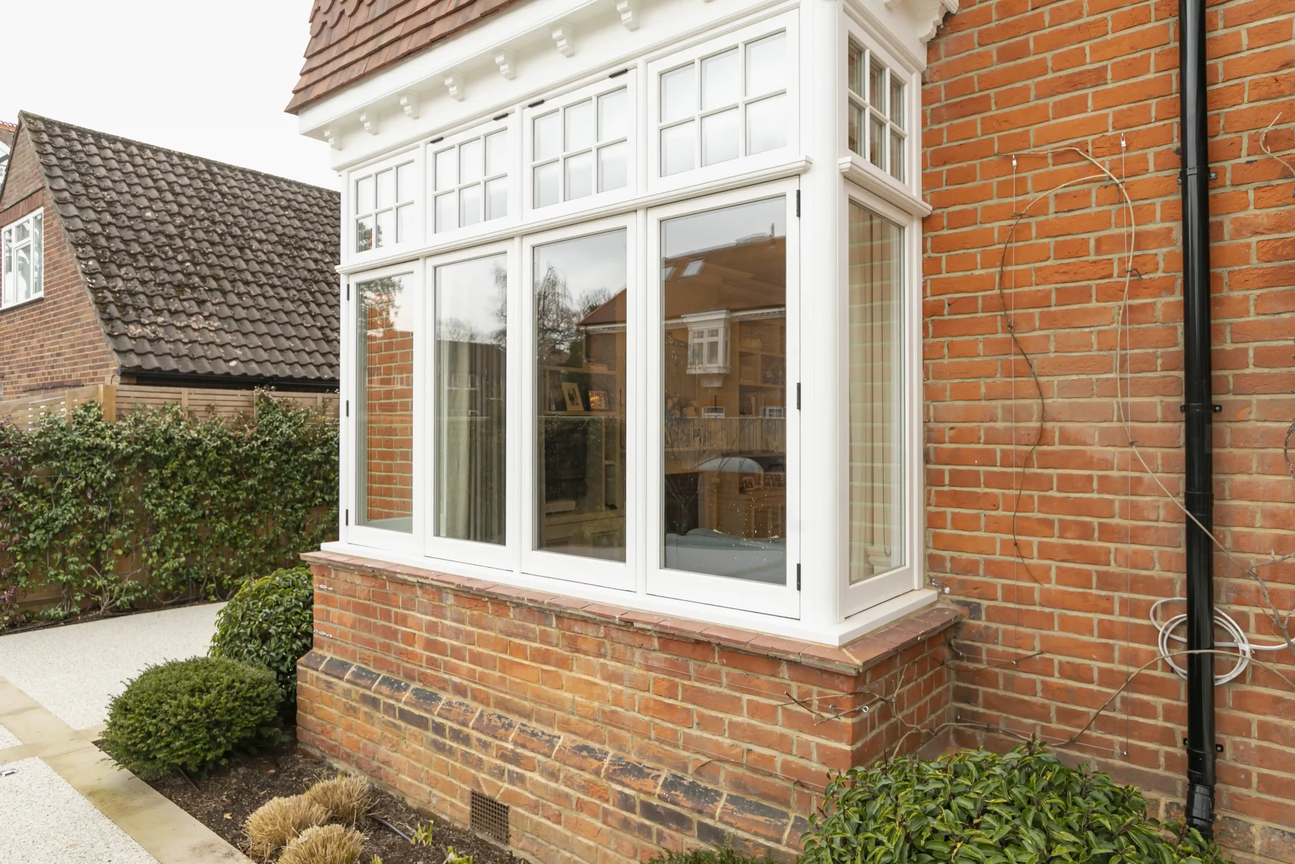 White 1930s windows in a brick bay extension