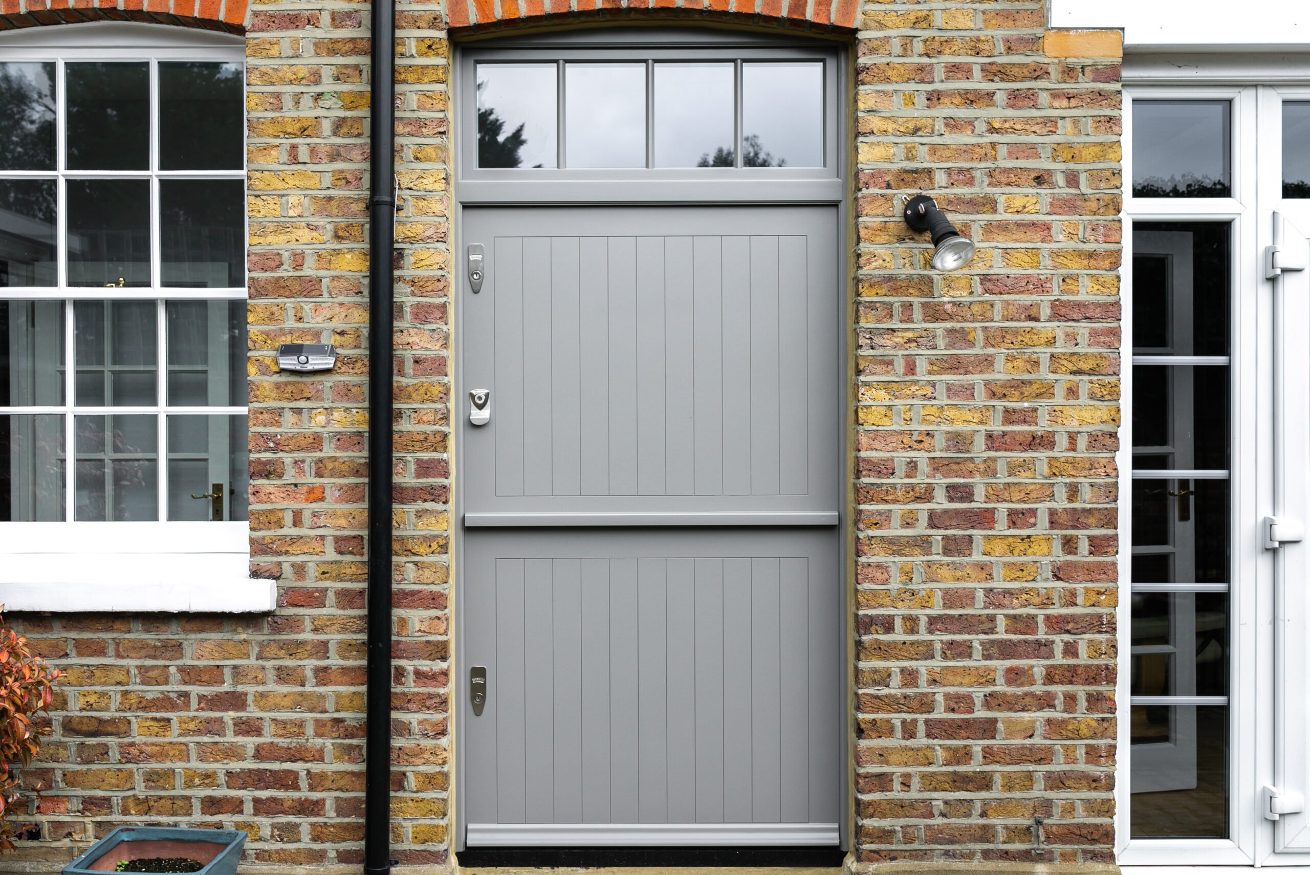 Wide grey front door with transom windows