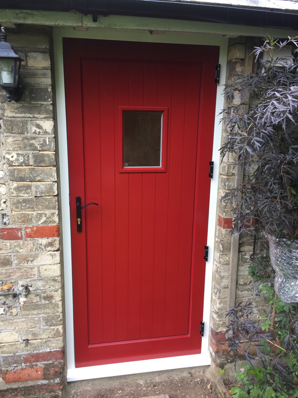 red timber exterior door with vision panel